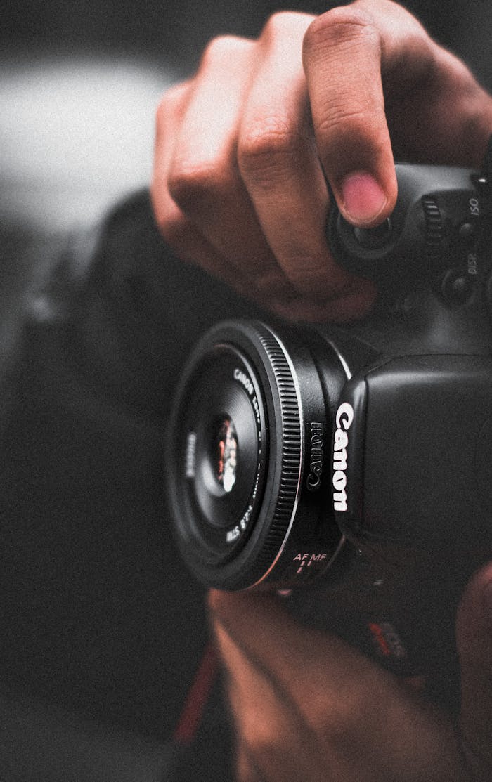 Close-up of a photographer adjusting settings on a DSLR camera.